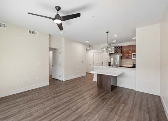 A room with a ceiling fan and wooden flooring.