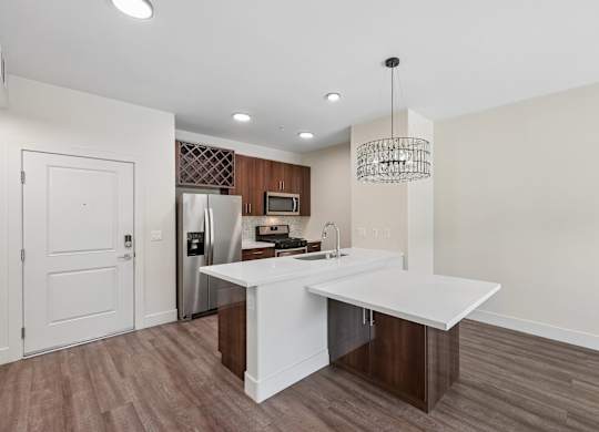 A kitchen with a white island and a refrigerator.