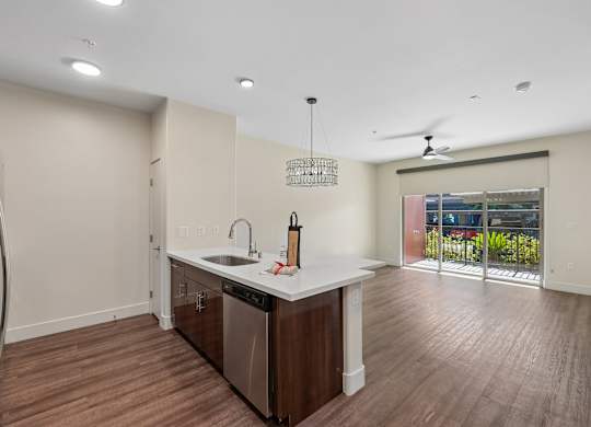 A modern kitchen with a wooden floor and white walls.