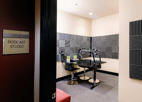 A podcast studio with a sign on the wall.