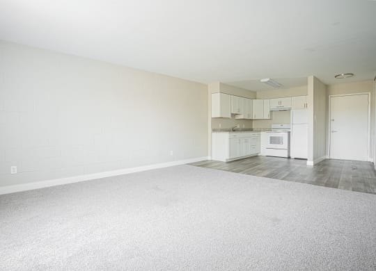 an empty living room and kitchen with white appliances at Regency Park, Reno