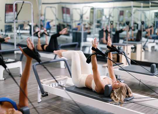 A woman is working out on a rowing machine in a gym.