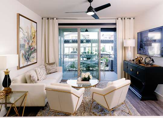 A living room with a white sofa, a coffee table, and a ceiling fan.