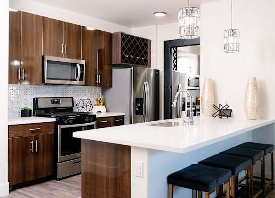 A kitchen with a white counter top and dark wood cabinets.