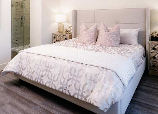 A bedroom with a large bed and a ceiling fan.