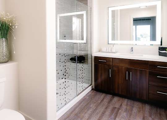 A bathroom with a toilet, a sink, and a mirror.