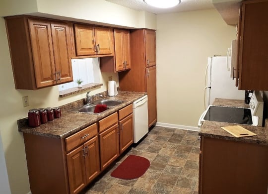 a kitchen with wooden cabinets and a white refrigerator at Monroeville Apartments, Pennslyvania, 15146