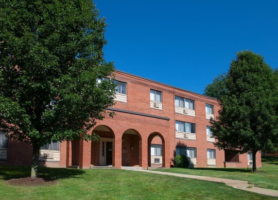 a brick building with trees in front of it at Monroeville Apartments, Monroeville, Pennslyvania
