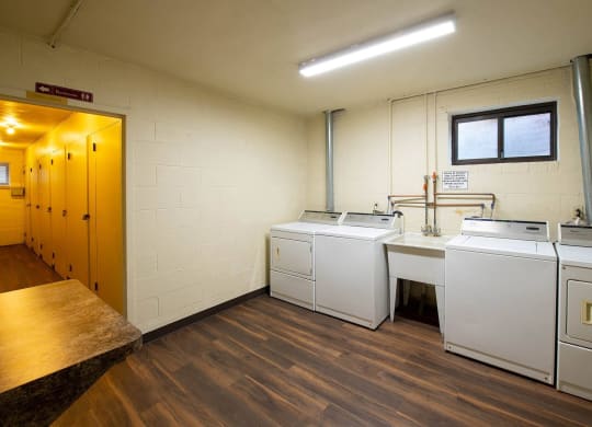 a laundry room with four washers and two dryers at Monroeville Apartments, Monroeville, 15146