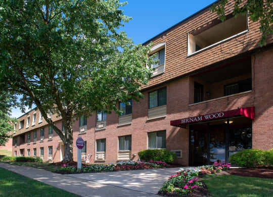 a brick building with a red awning and a sidewalk in front of it at Monroeville Apartments, Monroeville, PA, 15146