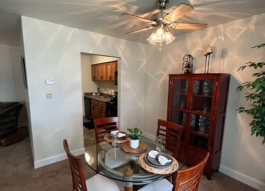 a dining room with a table and chairs and a ceiling fan at Monroeville Apartments, Monroeville, Pennslyvania