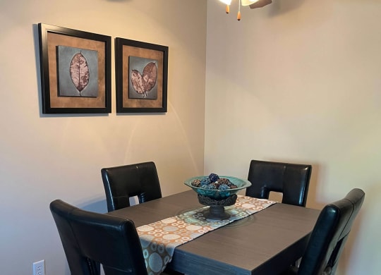 a dining room with a table and chairs and a ceiling fan at Monroeville Apartments, Monroeville, Pennslyvania