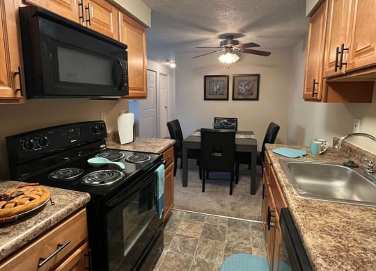 a kitchen with a stove top oven next to a sink at Monroeville Apartments, Pennslyvania
