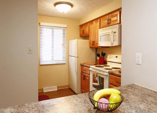kitchen with a white refrigerator freezer next to a stove top oven at Monroeville Apartments, Monroeville