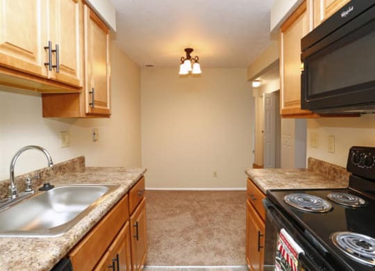 a kitchen with a stove and microwave at Monroeville Apartments, Monroeville