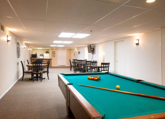 a game room with a pool table and chairs at Monroeville Apartments, Monroeville, Pennslyvania