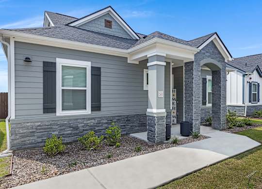A grey house with a white door and windows.
