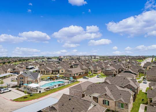 an aerial view of a suburb of houses with a swimming pool
