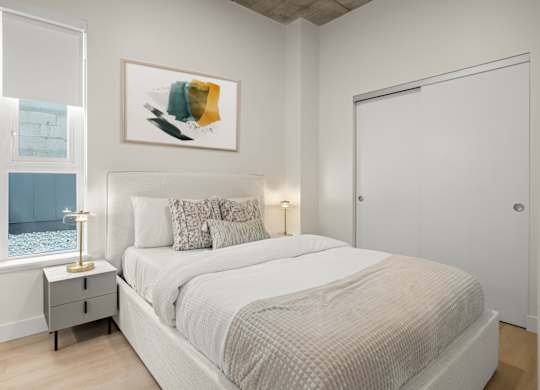 A bedroom with a large bed and a painting above it.