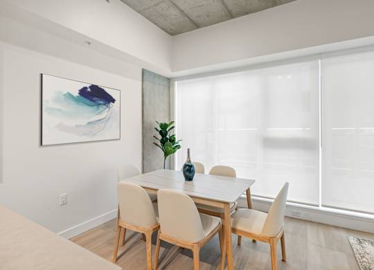 A dining room with a table and chairs.
