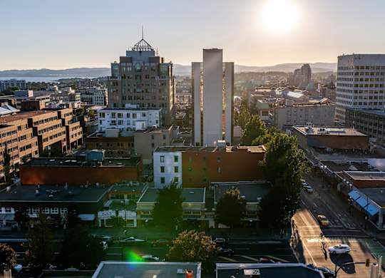 A cityscape with buildings and a sunset in the background.
