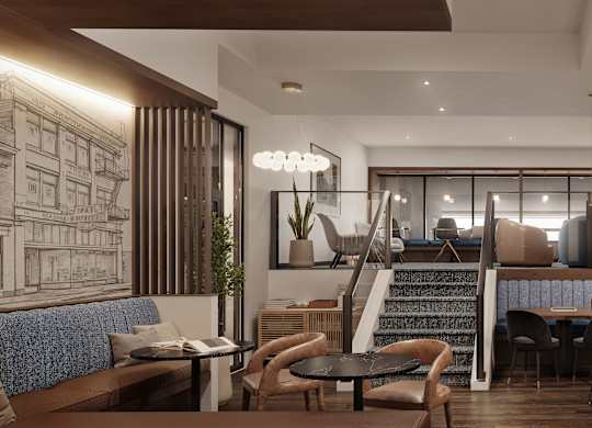 Modern kitchen area with tables and chairs and stairs leading up to a loft area.