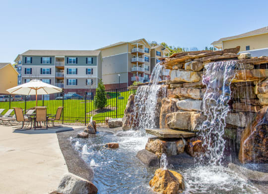 a water feature with a waterfall in front of an apartment building