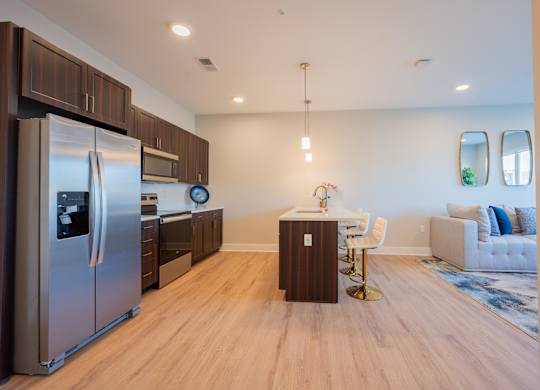A modern kitchen with a refrigerator, microwave, and oven.