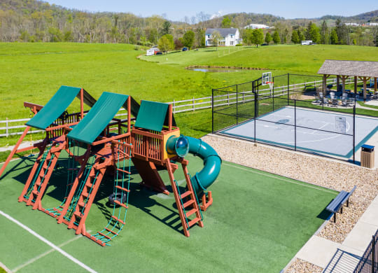 an aerial view of a playground with slides and a tennis court