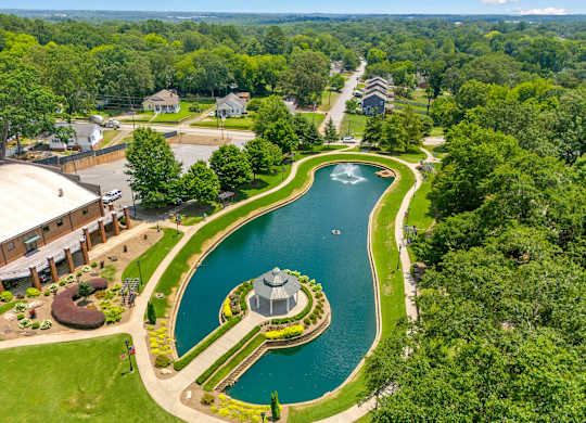 A serene landscape with a pond and a gazebo.