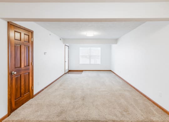 a room with a carpeted floor and a wooden door
