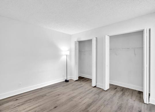 A room with a floor lamp and three open doors.