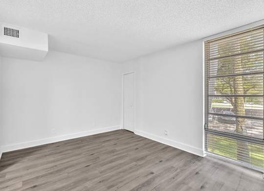 A room with a window and a wall-mounted air conditioner unit.