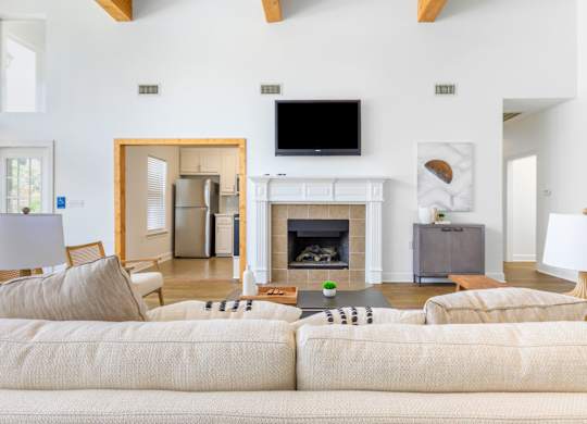 A living room with a fireplace and a television on the wall.