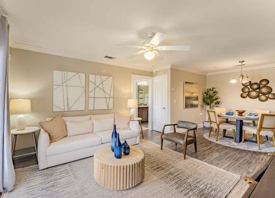 A living room with a white couch, a wooden coffee table, and a ceiling fan.
