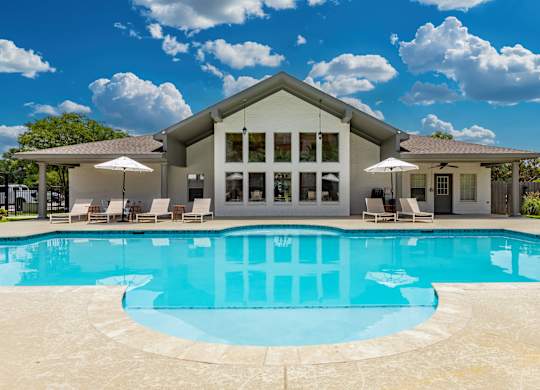 A large house with a pool in front.