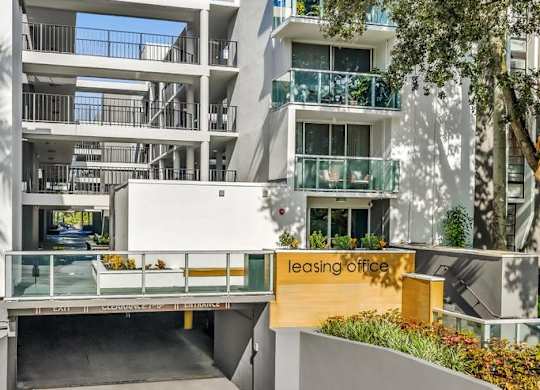 A modern building with a leasing office in front.