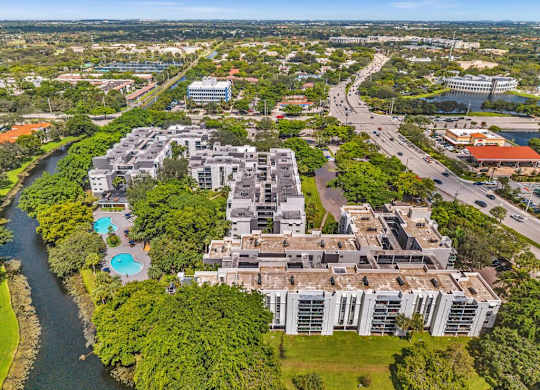 A large building complex is surrounded by a river and greenery.