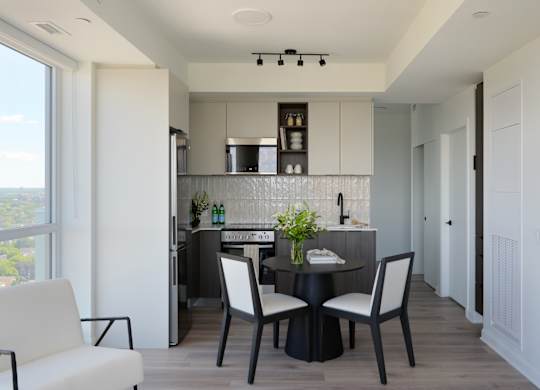 A modern kitchen with a dining table set for two.