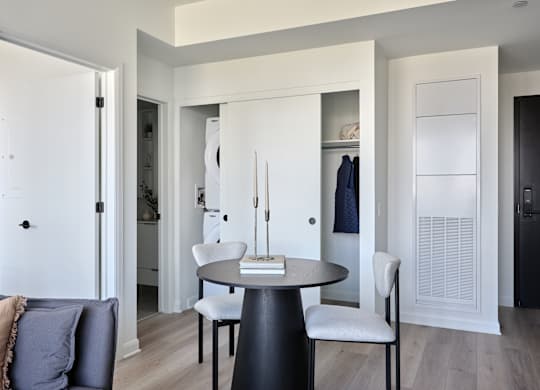 A modern dining room with a round table and chairs.