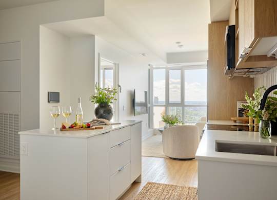 A modern kitchen with a white countertop and a large window.