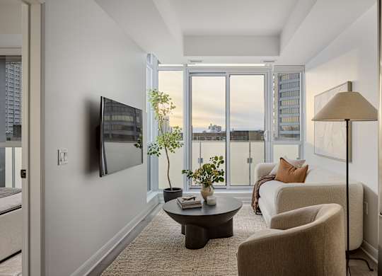 A living room with a flat screen TV mounted on the wall.