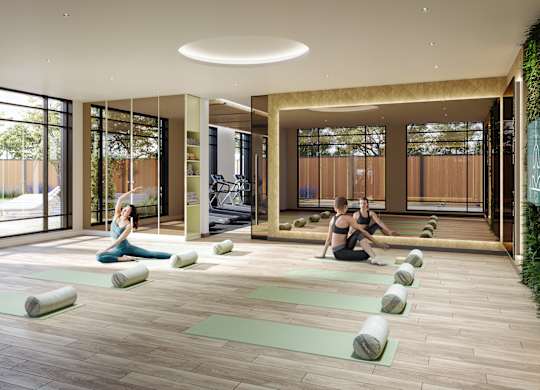 A yoga class is taking place in a spacious room with a large window.