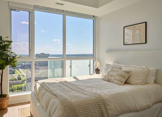 A bedroom with a large bed and a view of the city.