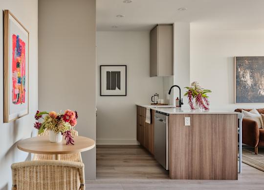 A modern kitchen with a wooden island and a dining table with chairs.