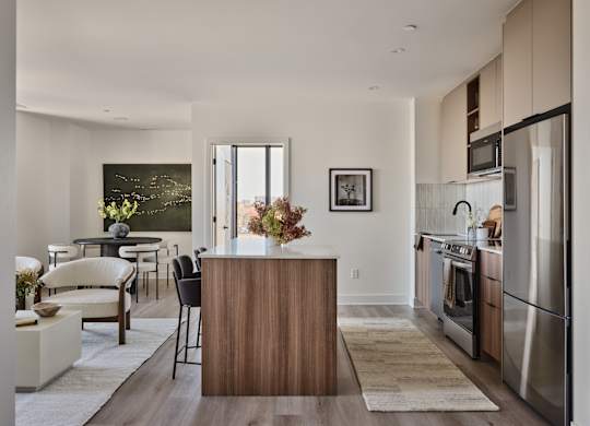 A modern kitchen with a wooden island and stainless steel appliances.