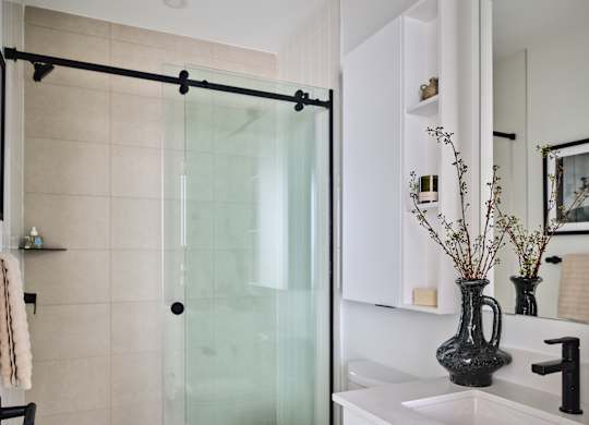 A white toilet sits next to a sink in a modern bathroom.