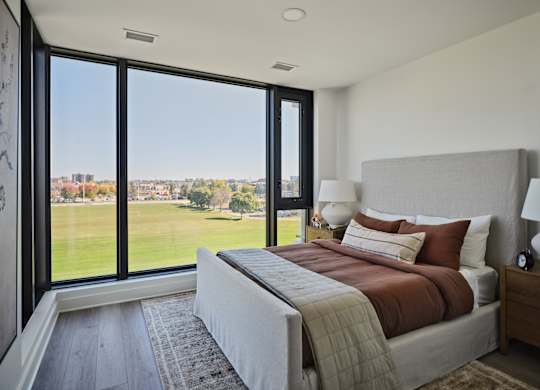 A bedroom with a large bed and a view of the outside.