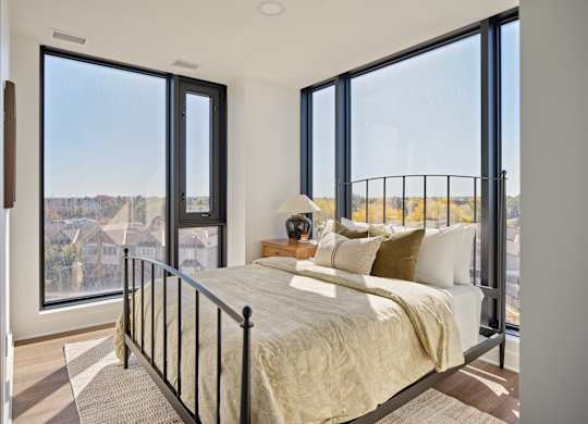 A bedroom with a large bed and a view of the city.