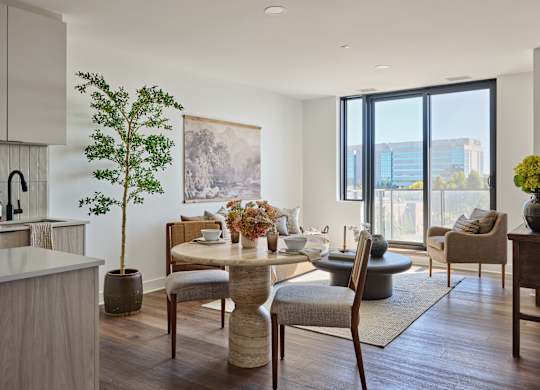 A modern dining room with a table set for two and a view of the city.